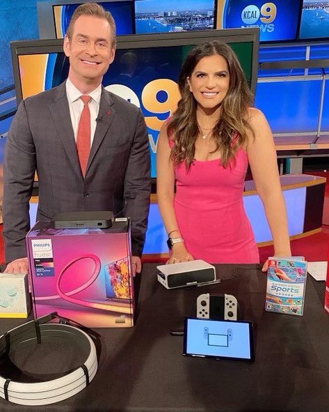 A man in a suit and tie and a woman in a pink dress are posing for a picture
