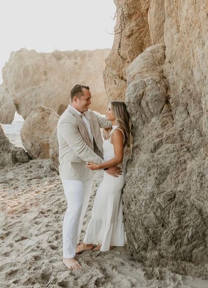 A man and a woman are standing next to each other on a beach.
