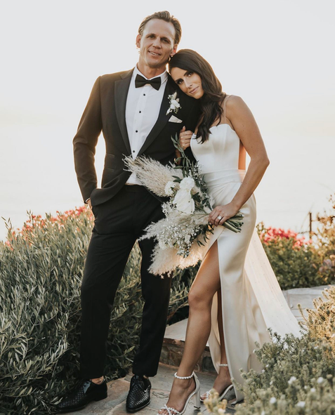 A bride and groom are posing for a picture on their wedding day.