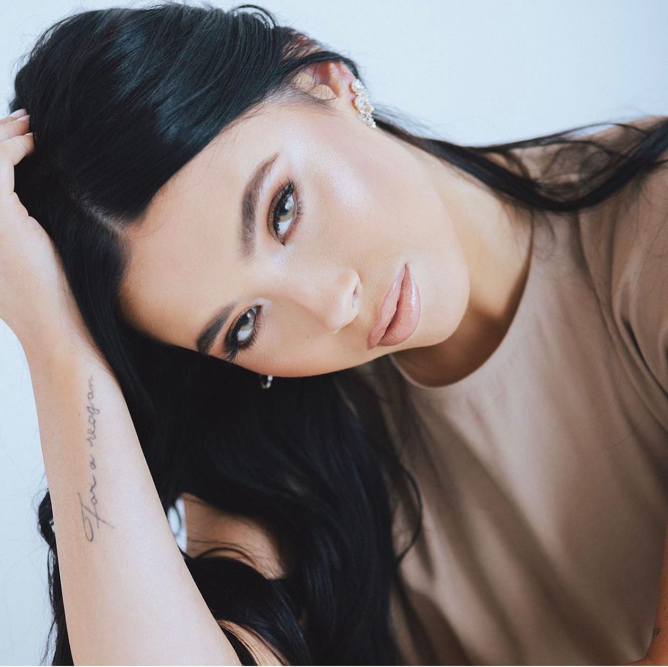 A woman is wearing a white dress with pearls and fringe.