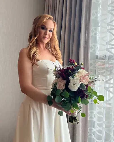 A woman in a white dress is holding a bouquet of flowers.