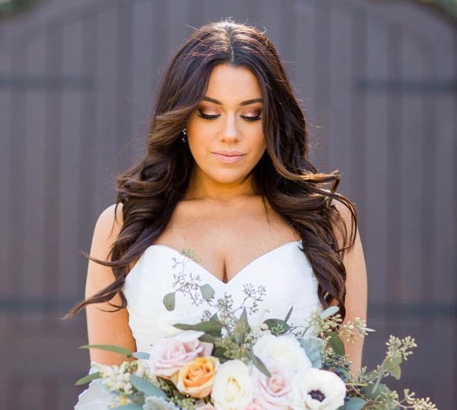 A woman in a white dress is holding a bouquet of flowers.