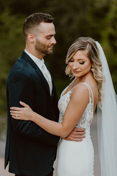 A bride and groom are posing for a picture on their wedding day.