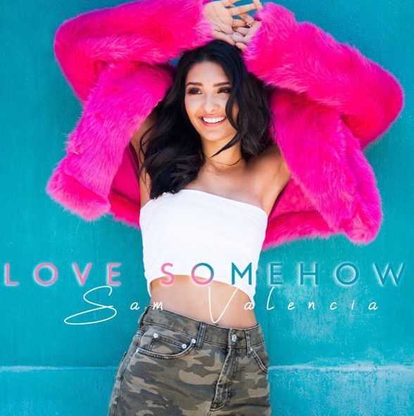 A woman wearing a pink fur coat is on the cover of love somehow