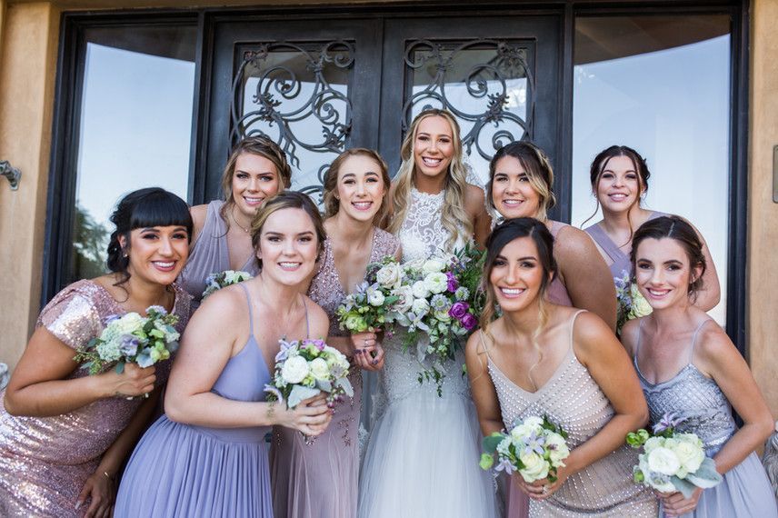 A bride and her bridesmaids are posing for a picture in front of a door.