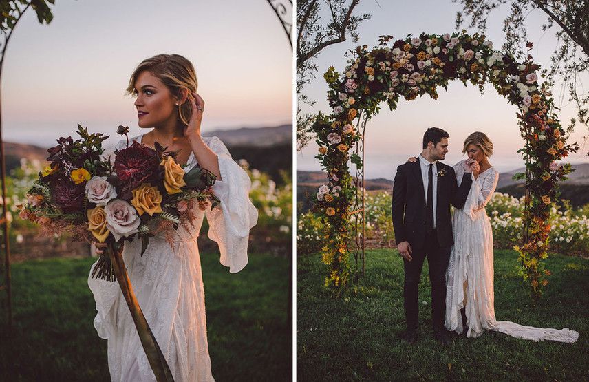 A bride and groom are standing under a floral arch.