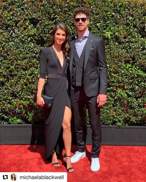A man and a woman are posing for a picture on a red carpet