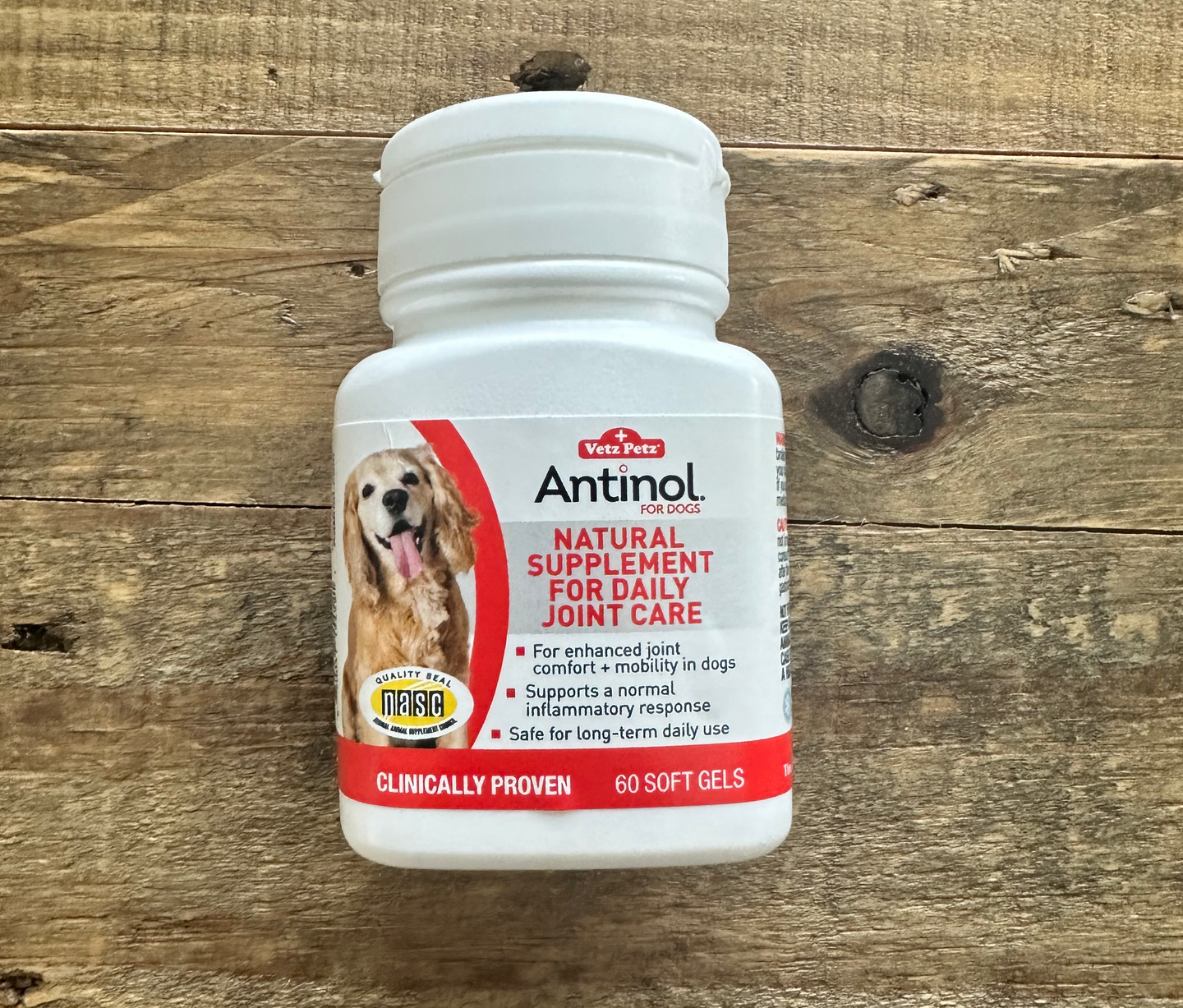 a bottle of antnol plus natural supplement for daily joint care is sitting on a wooden table .