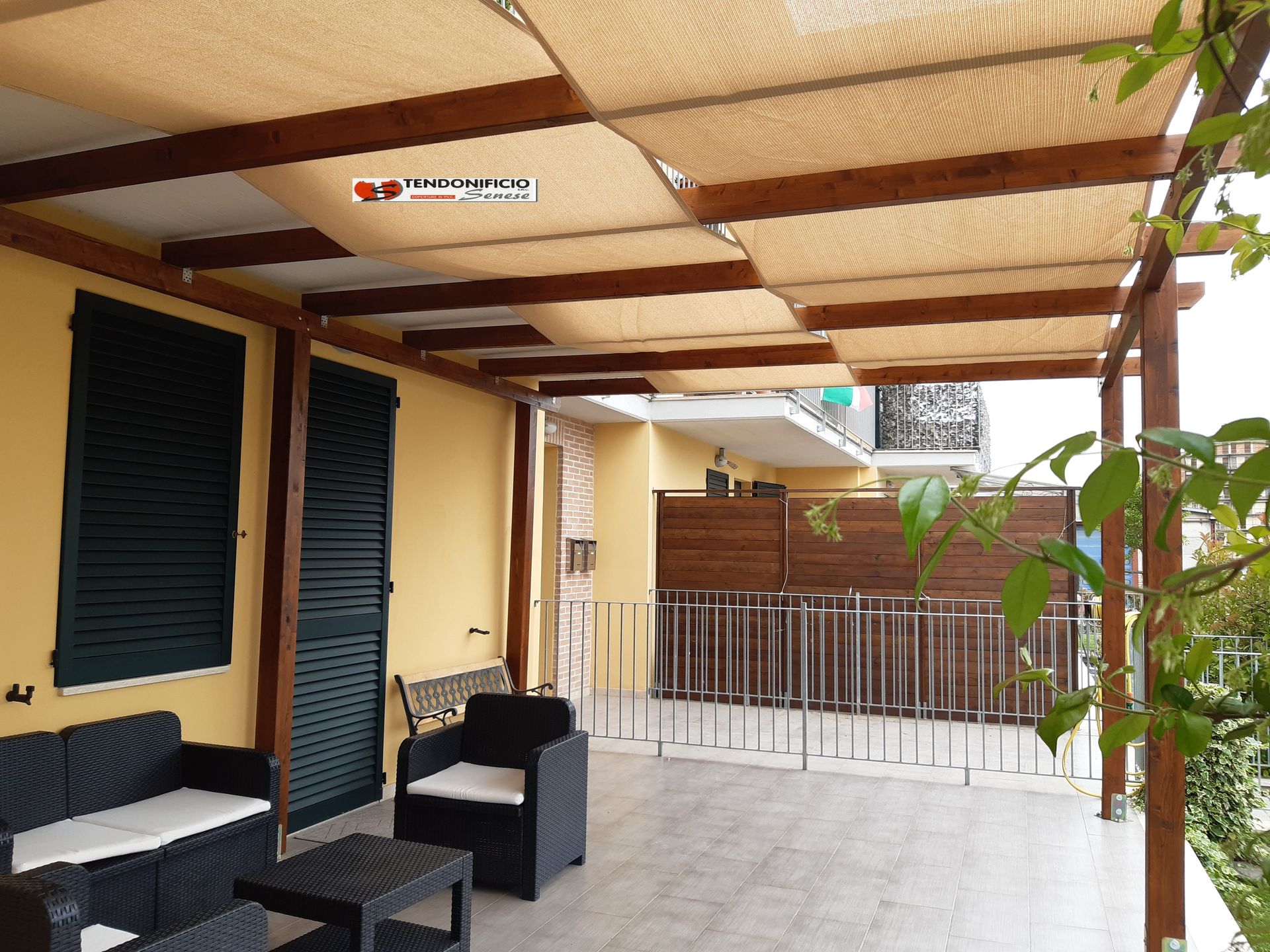 un portico con divano e sedie sotto una tettoia