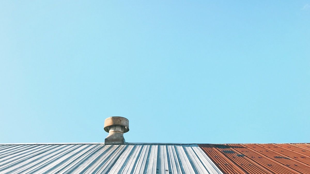A Roof With A Chimney On Top Of It And A Blue Sky In The Background – Melbourne, VIC - Above & Beyond Roof Replacements