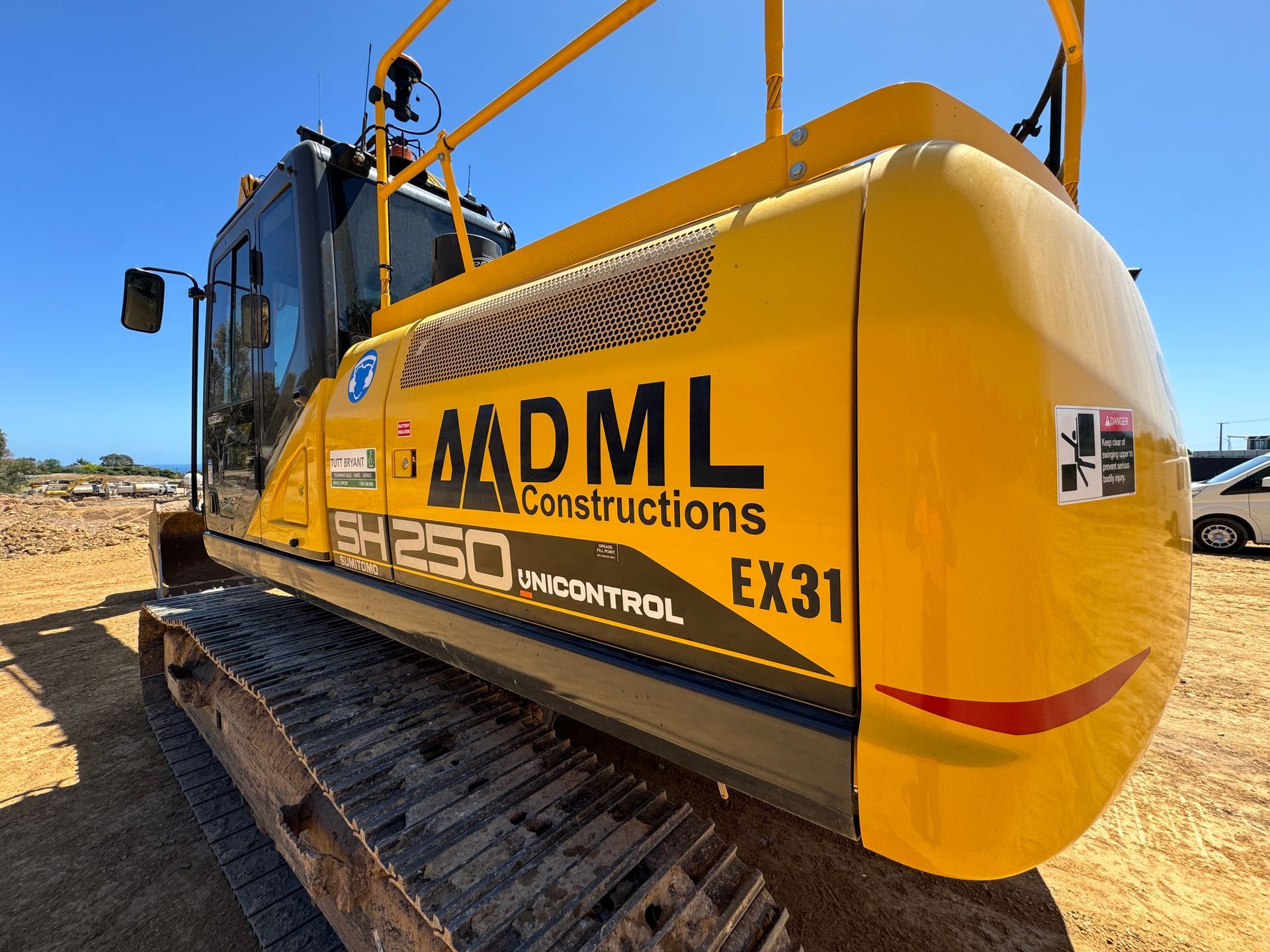 Yellow Caterpillar excavator with bucket on gravel.