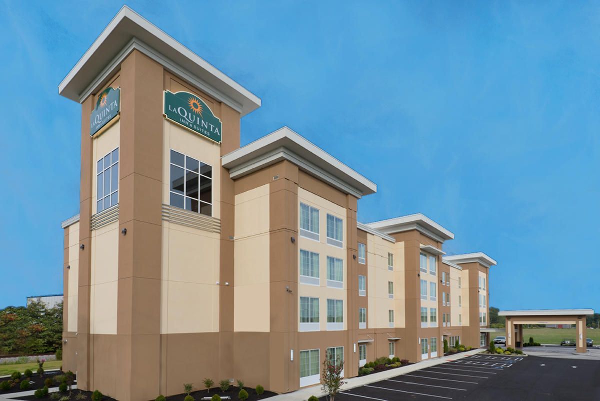 Hotel building with brown and beige facade against a blue sky.