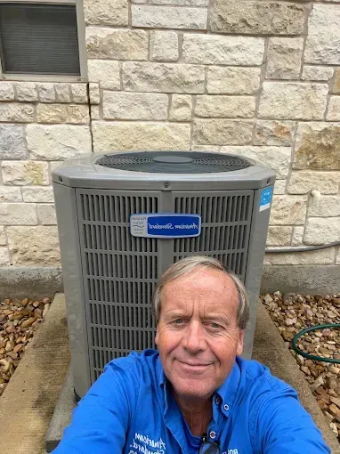 A man is taking a selfie in front of an air conditioner.