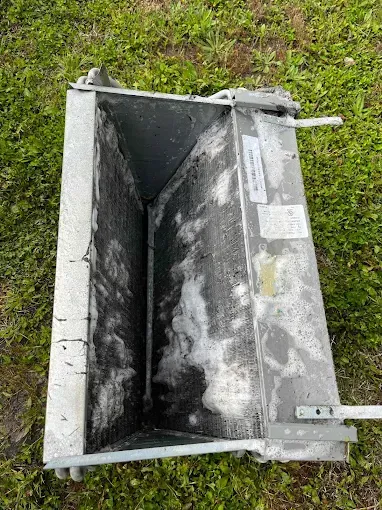 A metal bucket is sitting on top of a lush green field.