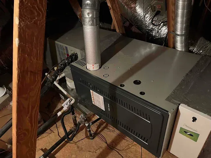 An air conditioner is sitting in the attic of a house.