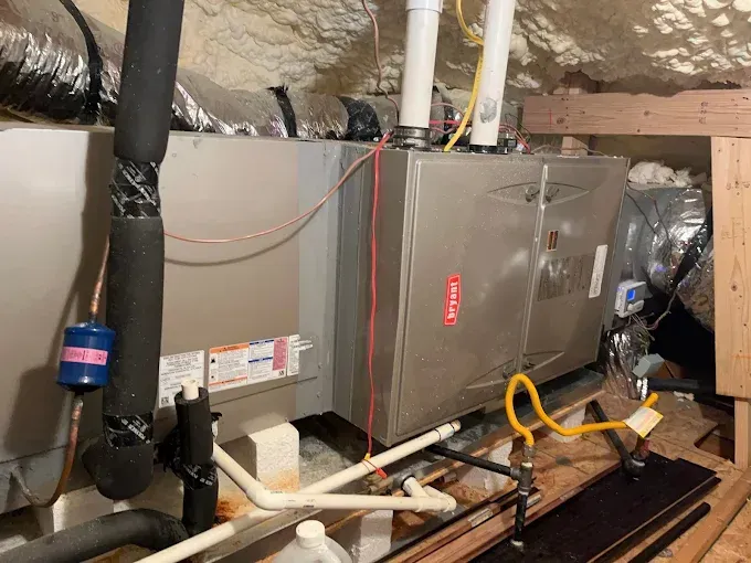 A couple of air conditioners are sitting on top of a wooden table in a basement.