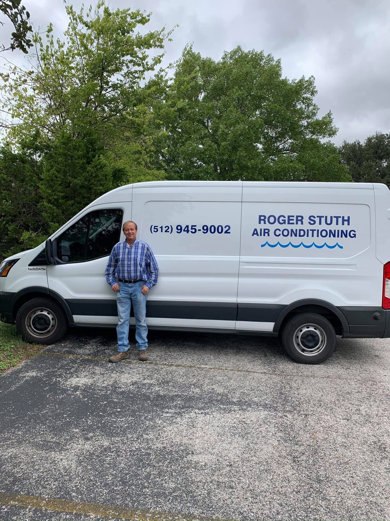 A man is standing in front of a white van.