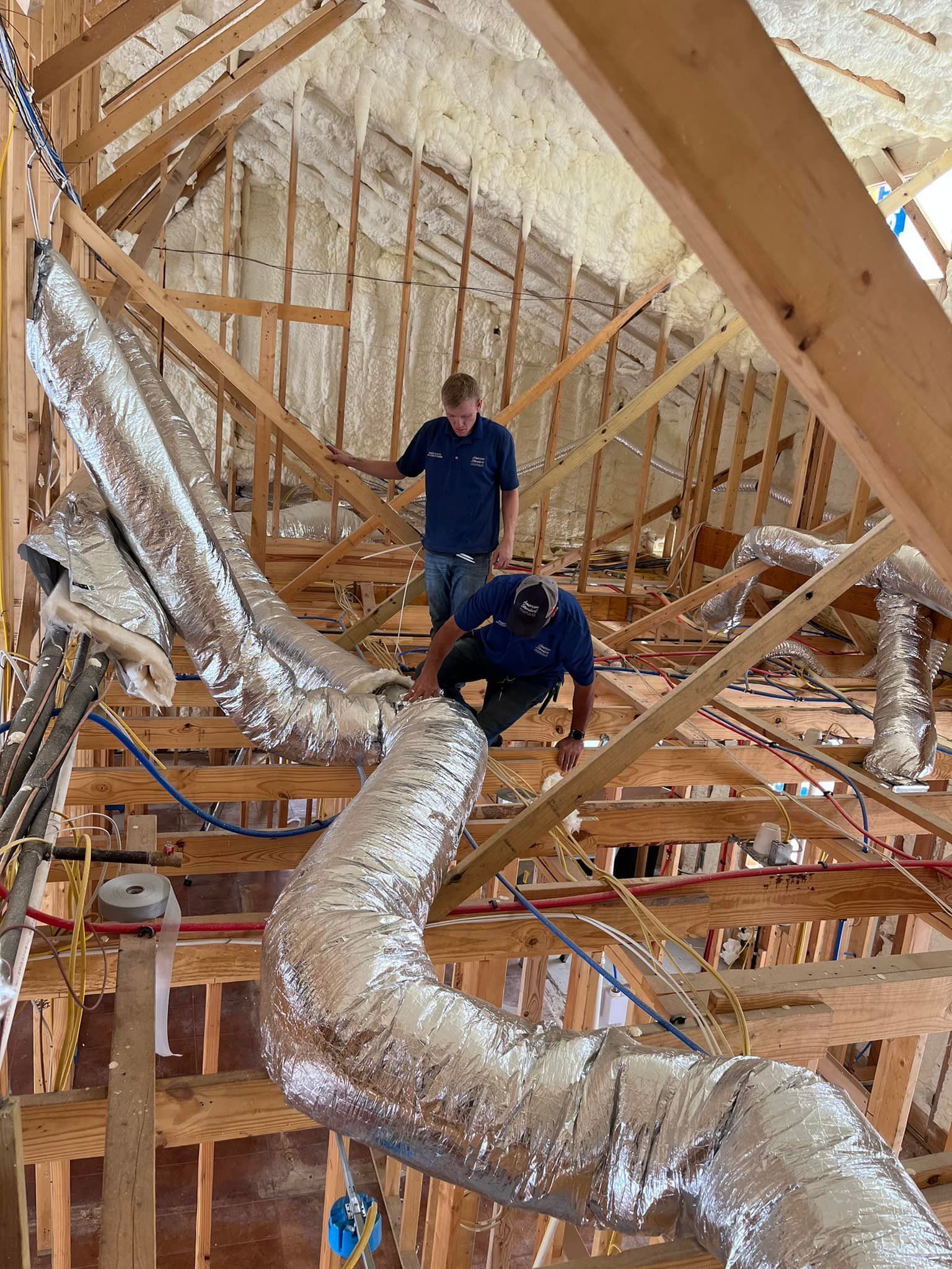 A man is standing in the attic of a house under construction.