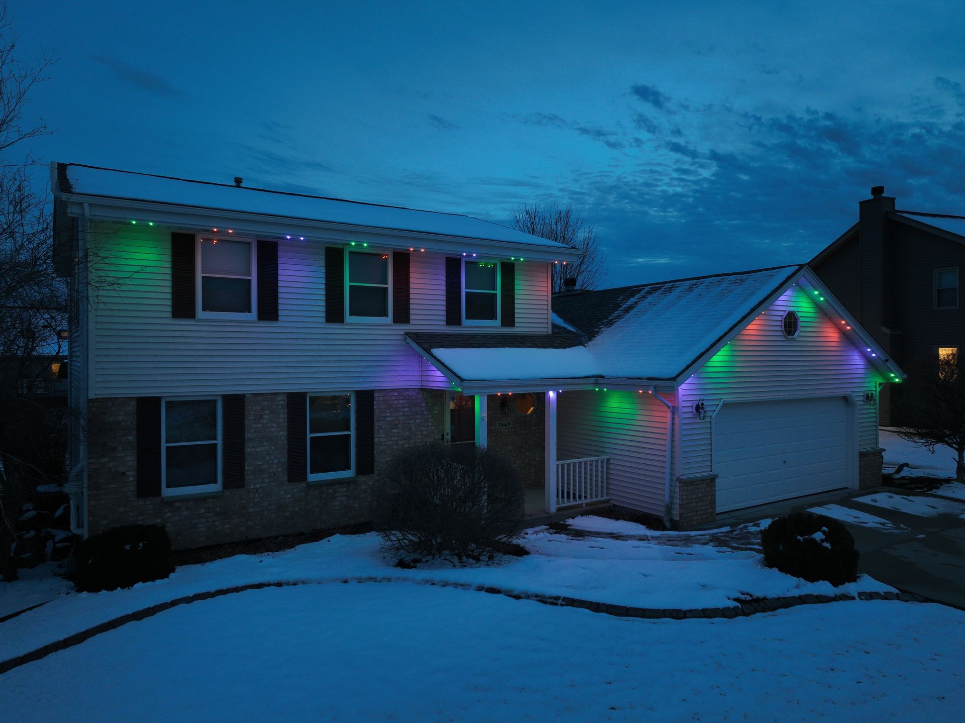 A house with Halloween Monster Eyes thematic lights on it is covered in snow
