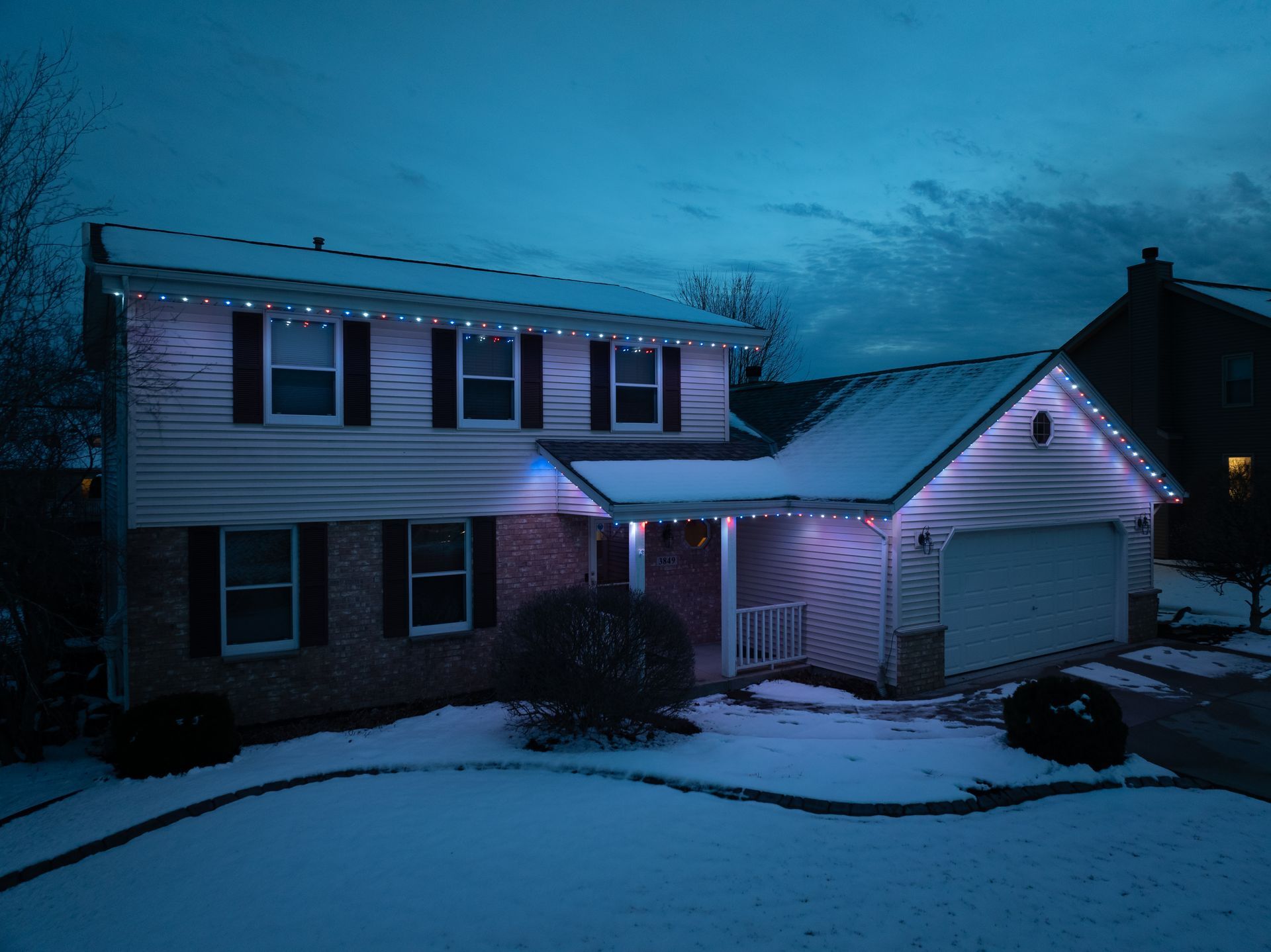 A house with white lights on it is covered in snow