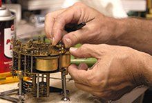 Clock Supplies — Worker Fixing Clock Part in Wayland, MA