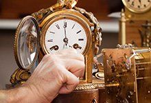 New Clocks — Man Winding Clock Hands in Wayland, MA