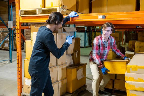 A man and a woman are working in a warehouse.
