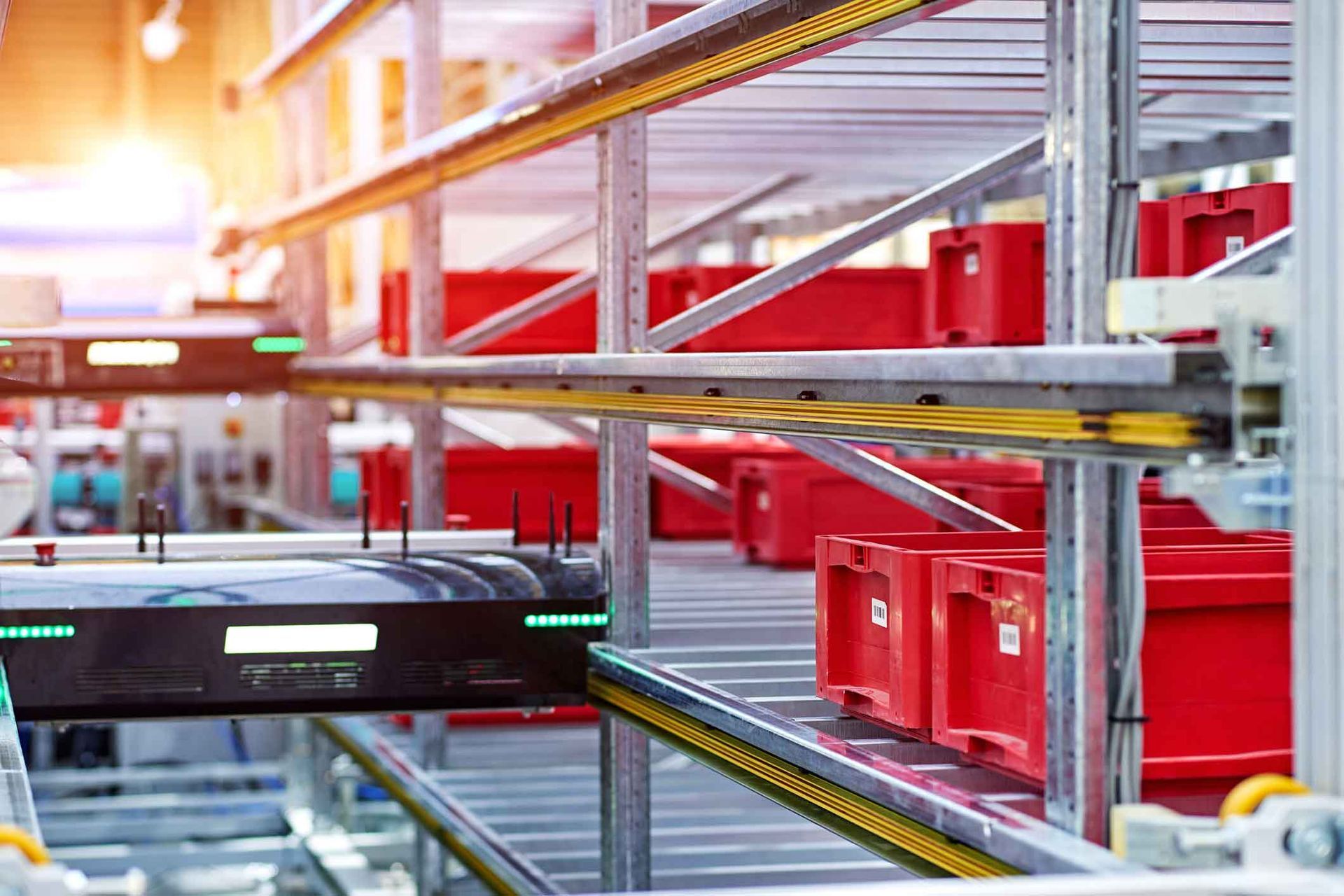 A conveyor belt in a warehouse filled with red boxes.