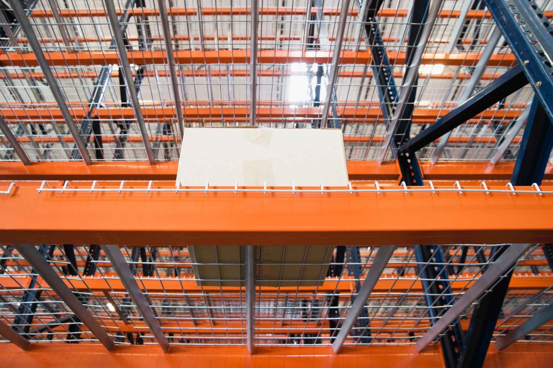 Looking up at the ceiling of a warehouse with lots of shelves.