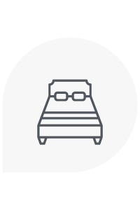 Icono de cama con dos almohadas, dentro de un rectángulo redondeado gris claro.