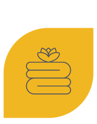 Pila de toallas dobladas con flor encima, fondo amarillo.