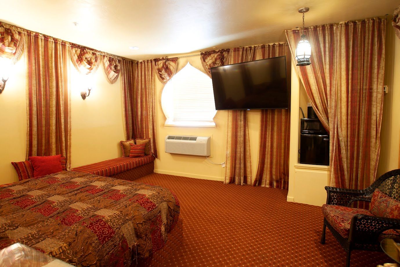 A hotel room with two beds and a flat screen tv