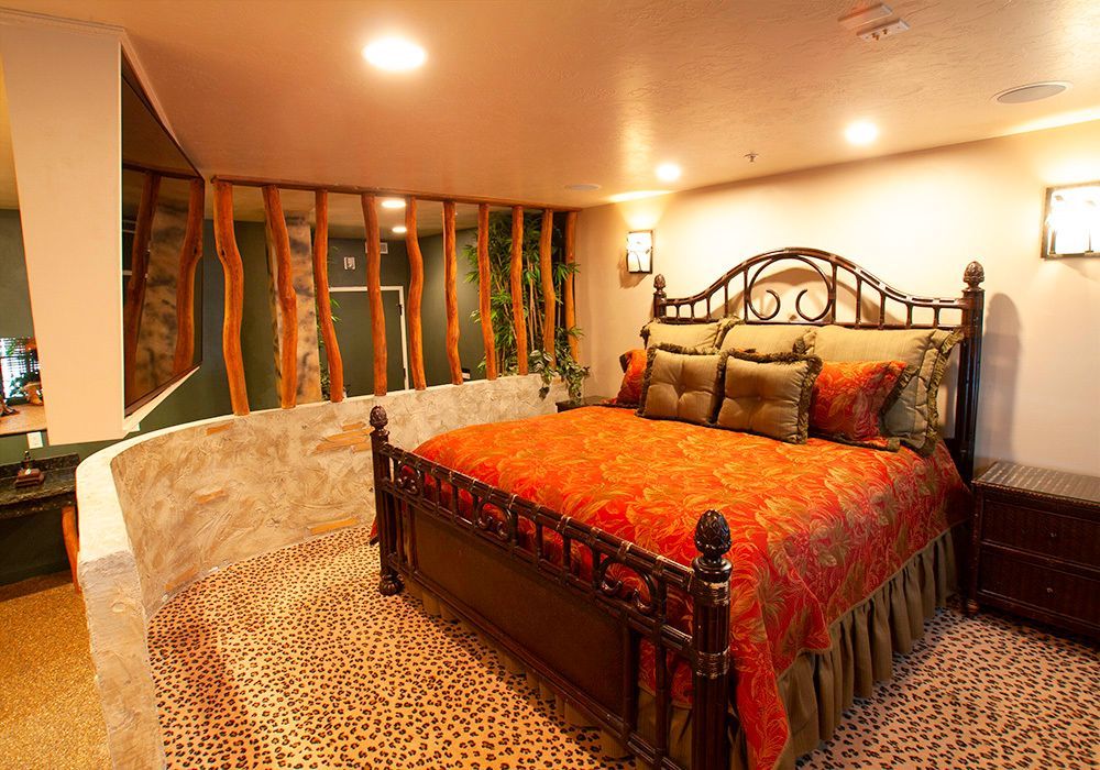 A bedroom with a large bed and a leopard print floor