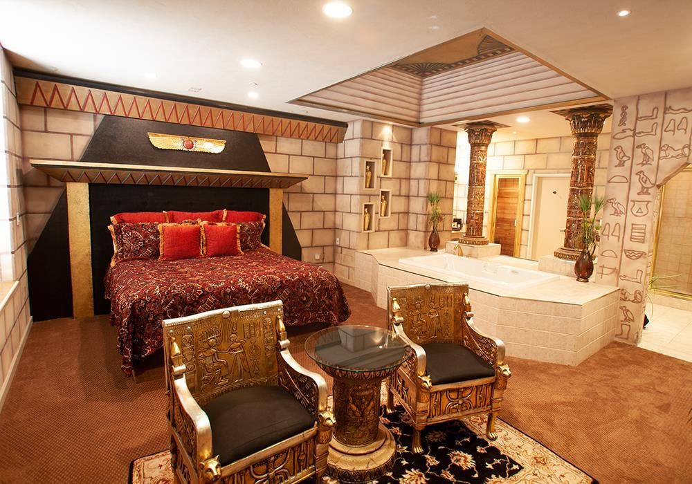 A bedroom with a king size bed and two chairs