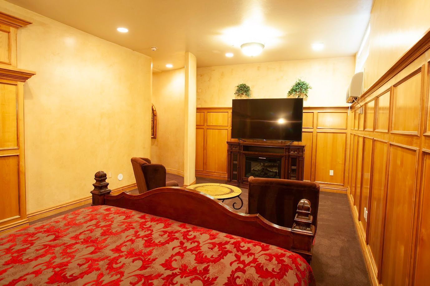 A bedroom with a large bed and a flat screen tv.