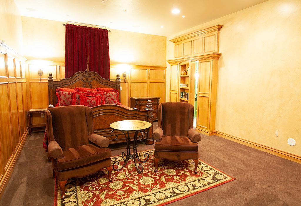 A bedroom with a king size bed and two chairs