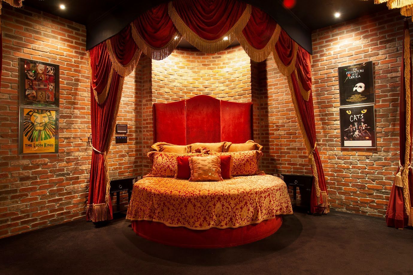 A bedroom with a round bed and a brick wall