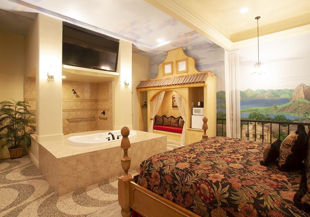 A bedroom with a king size bed and a jacuzzi tub