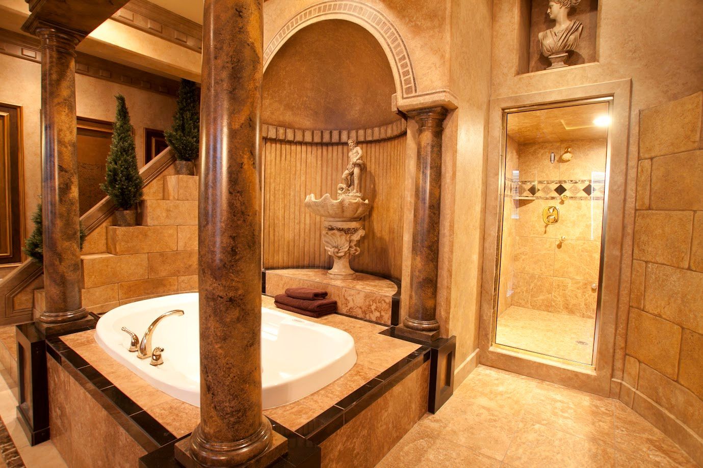 A bathroom with a bathtub surrounded by columns and a shower.