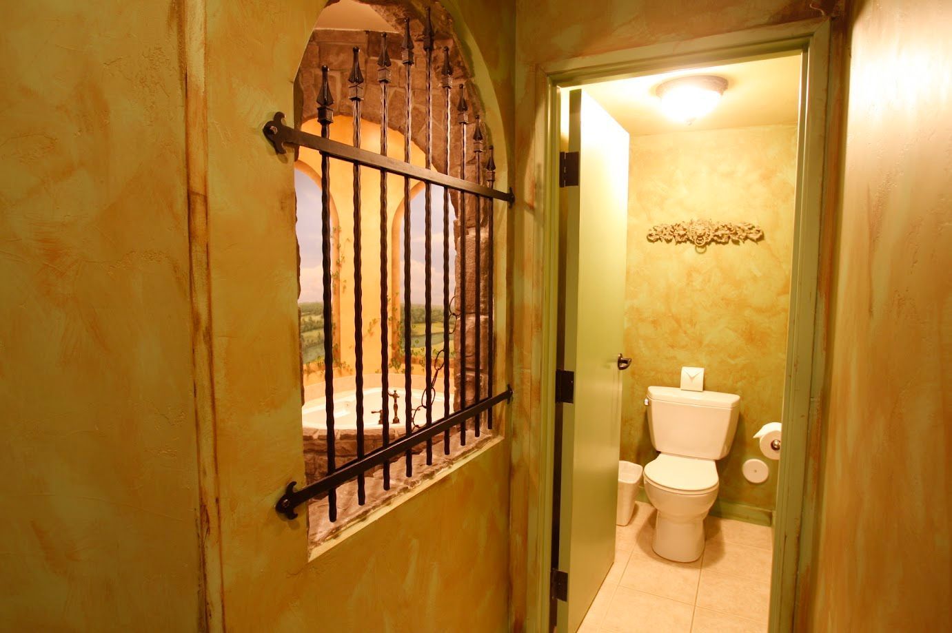 A bathroom with a toilet and a window with bars on it.