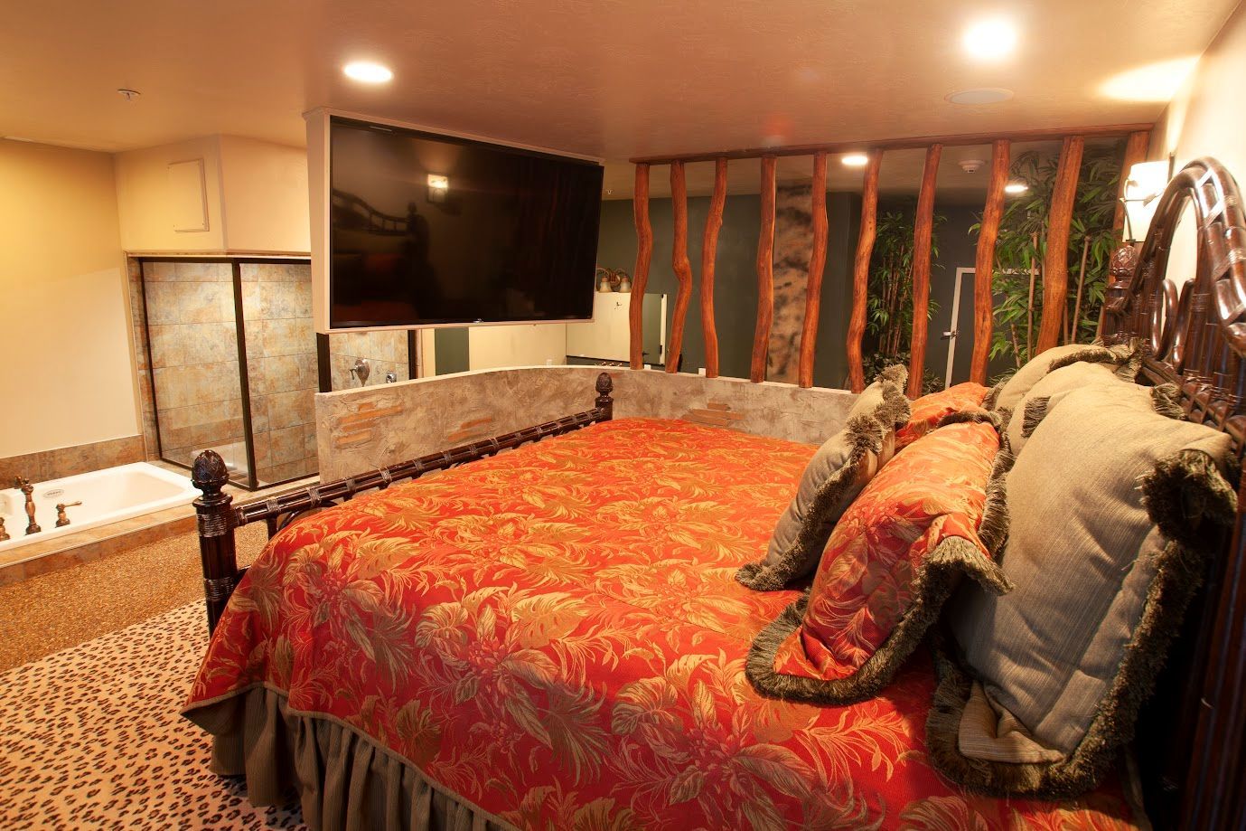 A bedroom with a large bed and a flat screen tv.