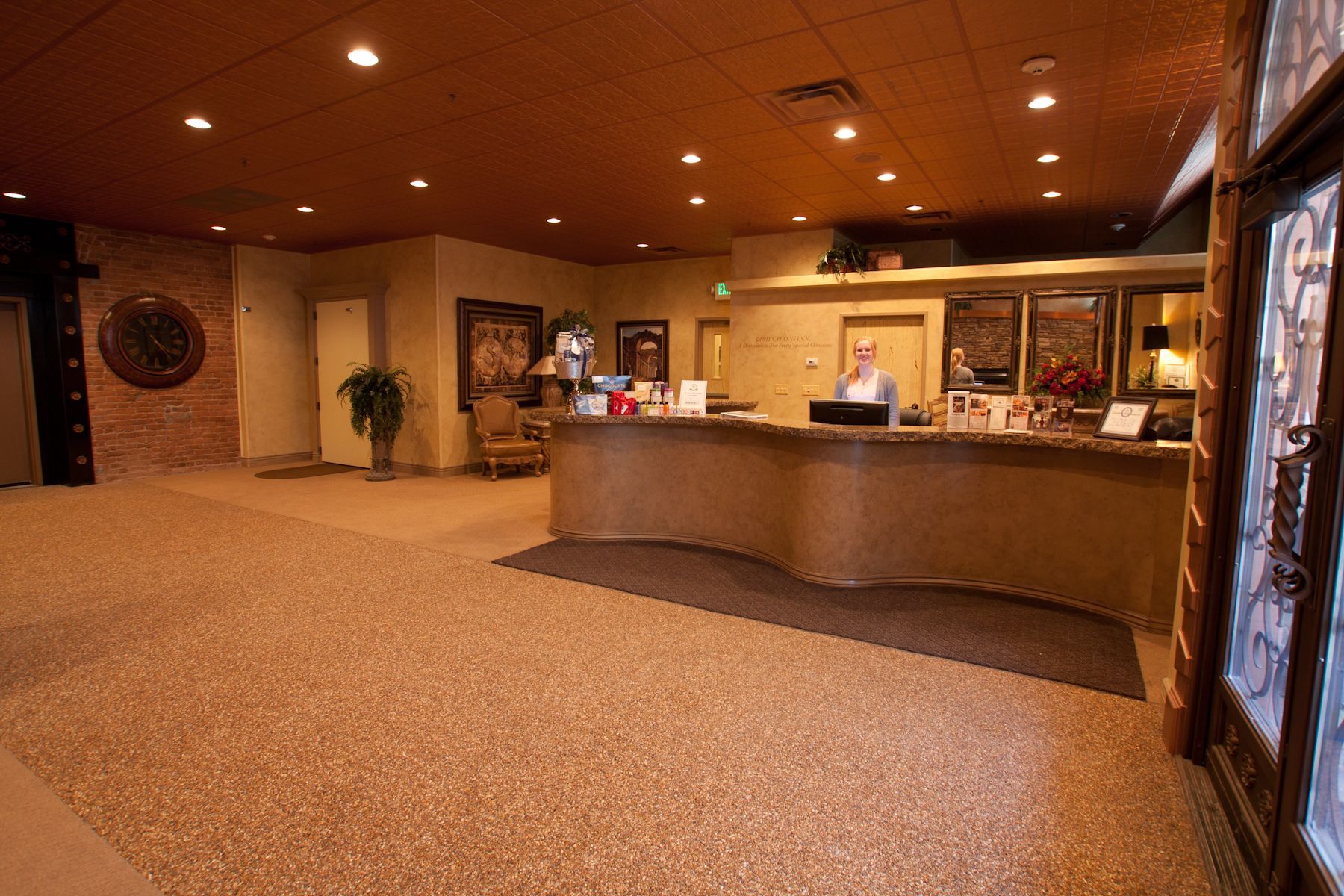 A woman is standing at a counter in a hotel lobby.