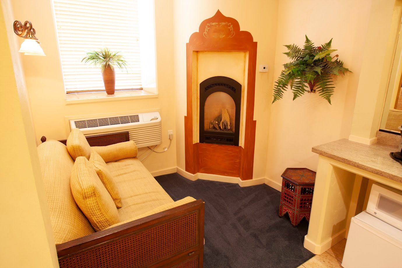 A living room with a couch and a fireplace in the corner