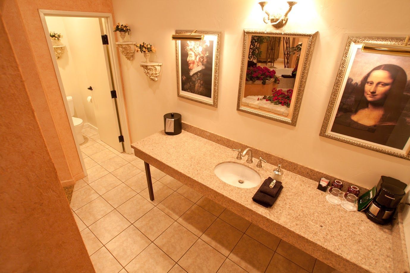 A bathroom with a sink and two paintings on the wall