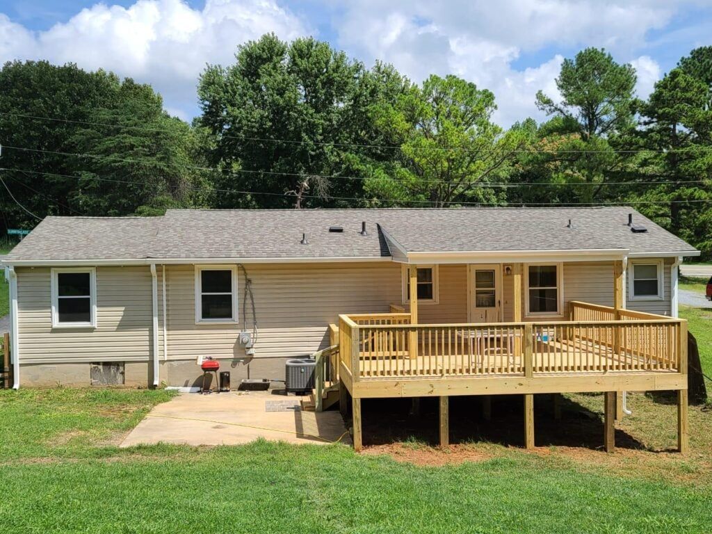 The back of a house with a large wooden deck.
