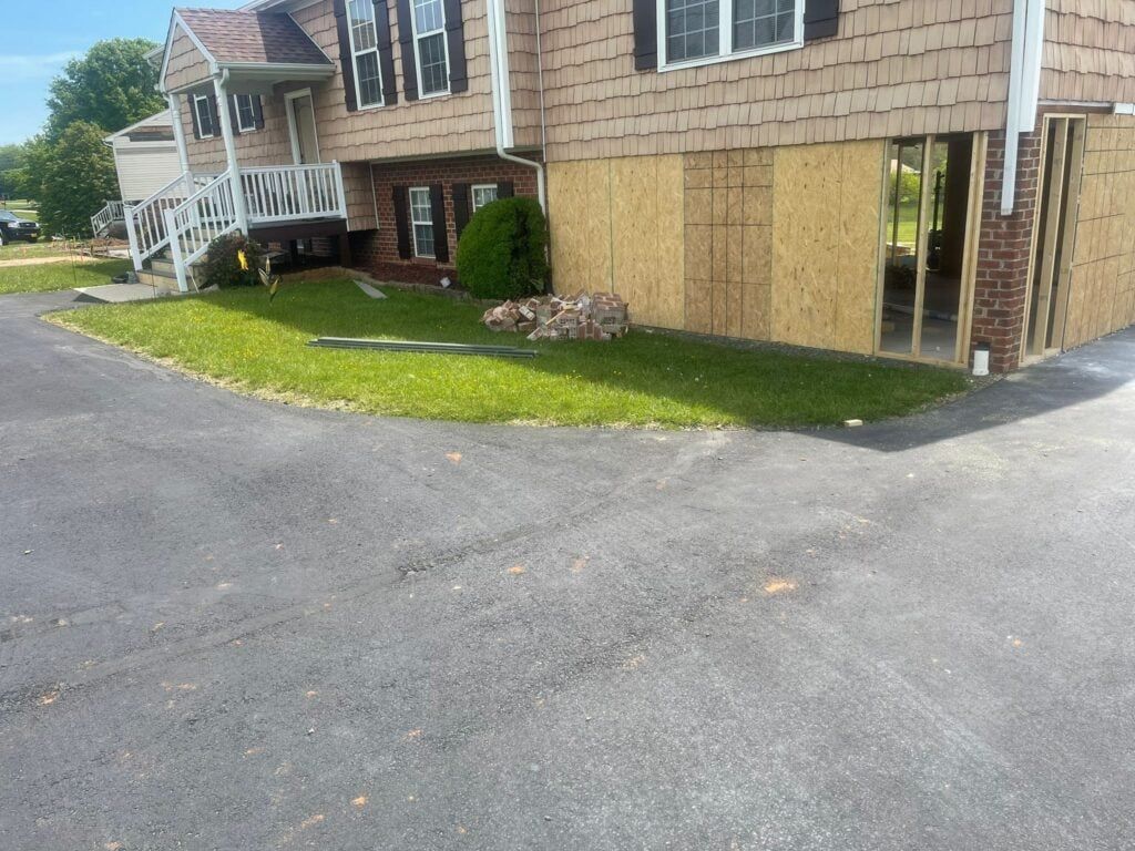A house that is being remodeled with a driveway in front of it