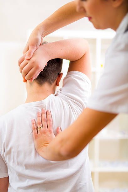 Chiropractor adjusting a patient's neck, using hands on neck and back in an office setting.
