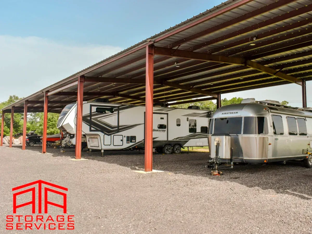A rv is parked under a roof with air storage services written on the bottom