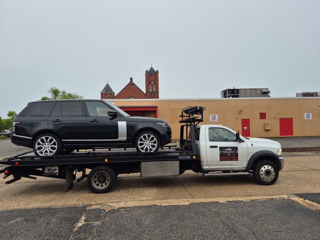 A white tow truck is parked on the side of the road.