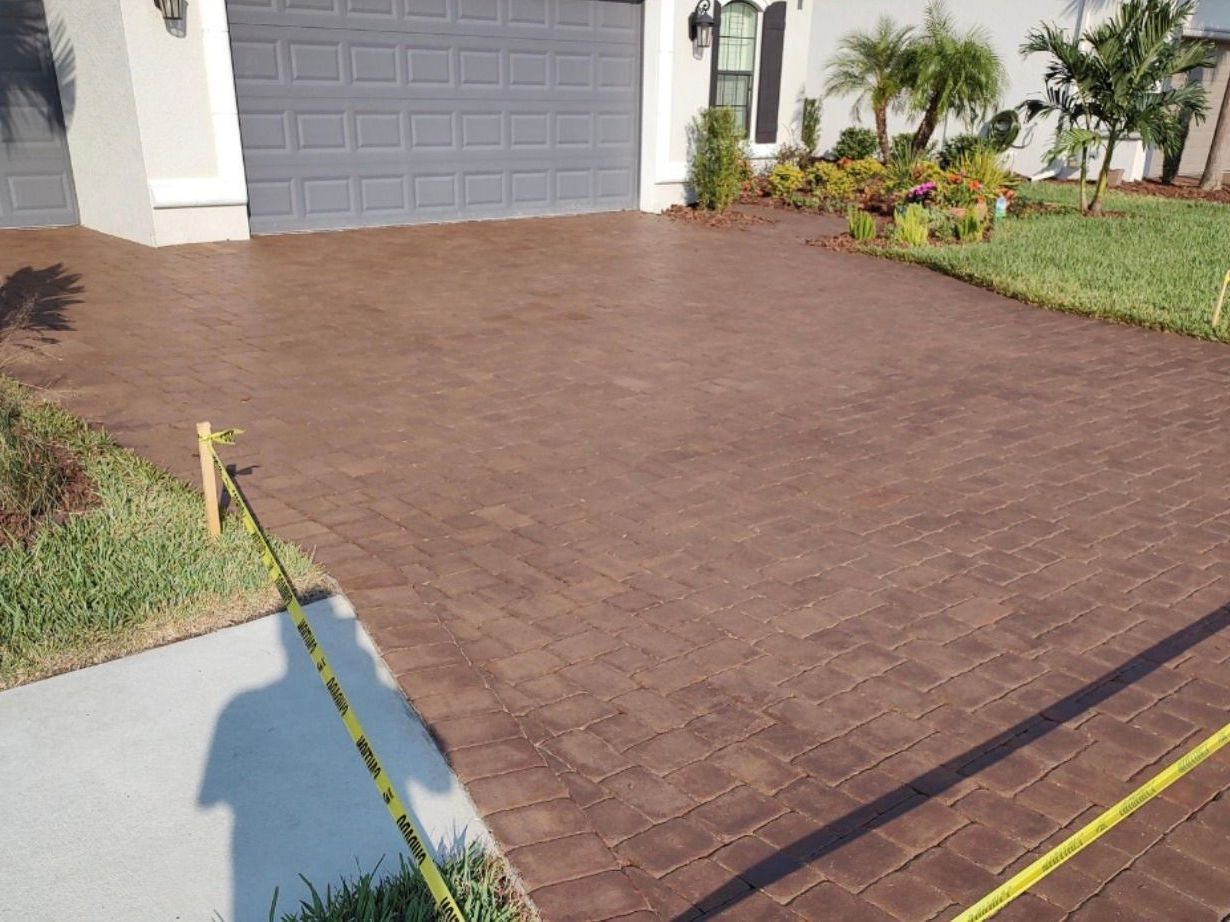 a brick driveway is being painted in front of a house .